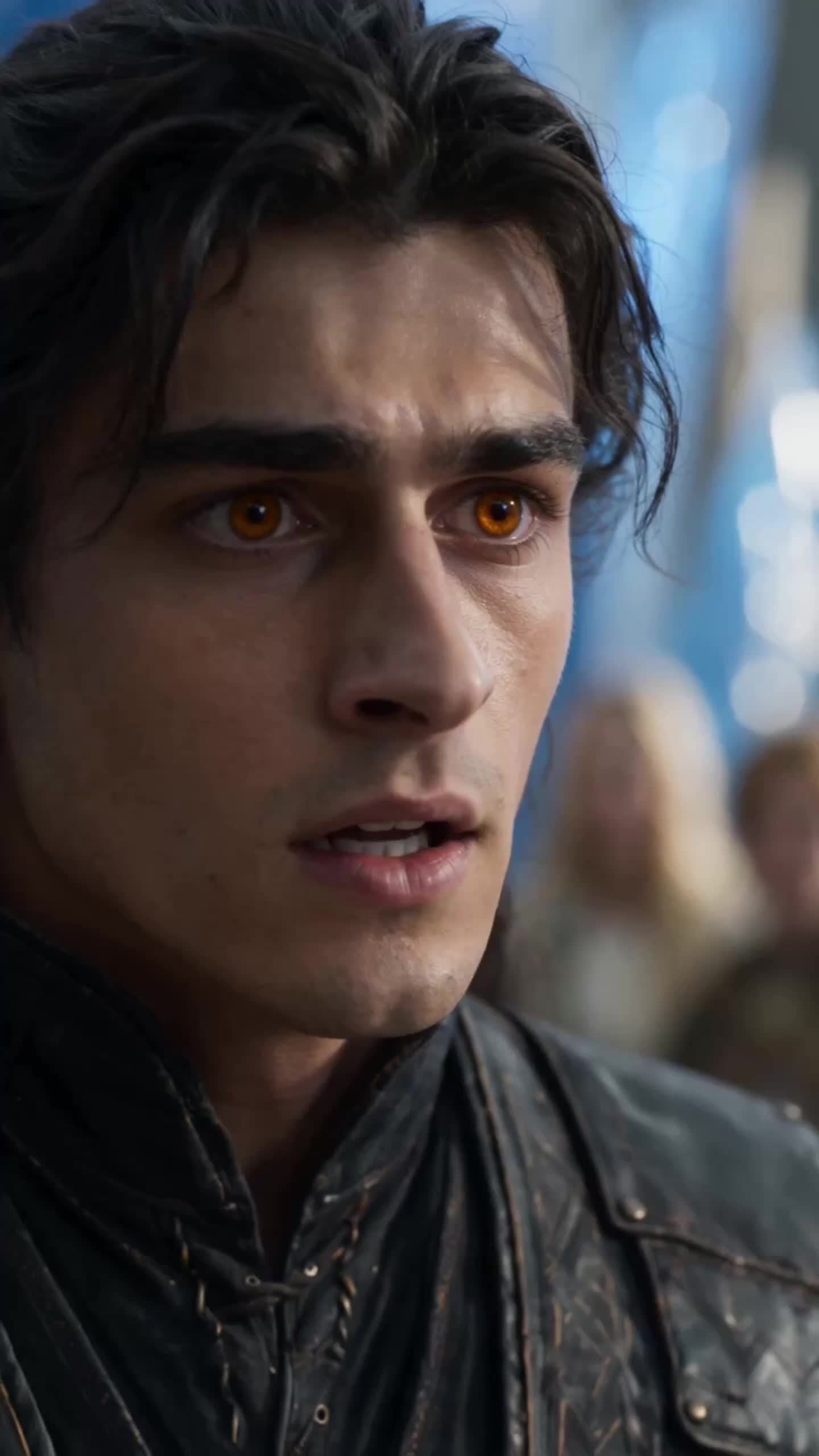 Close-up of Cedric’s face, black hair falling over his forehead, amber eyes wide and lips parted, in a black leather coat with a blurred crowd behind